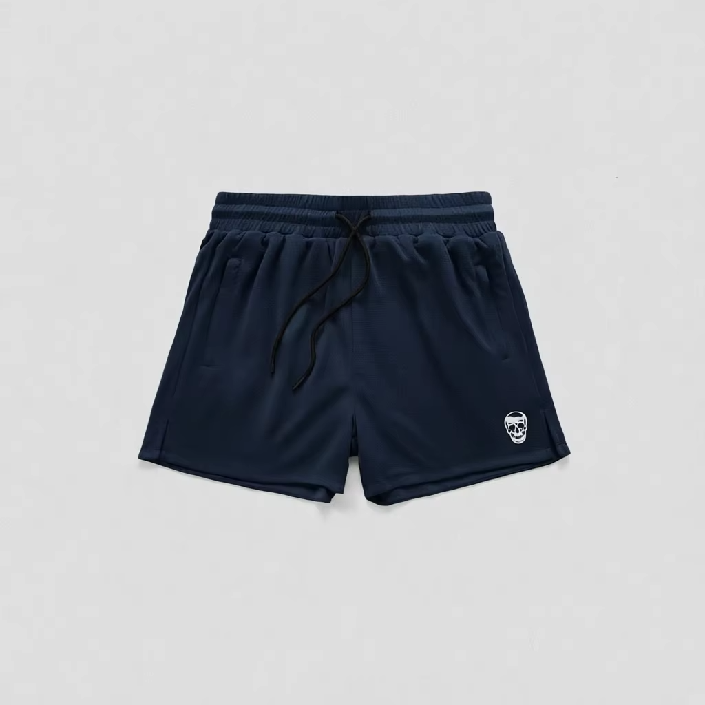 Navy blue athletic shorts with a black drawstring and a small white skull logo on the lower left leg, shown flat on a light gray background.