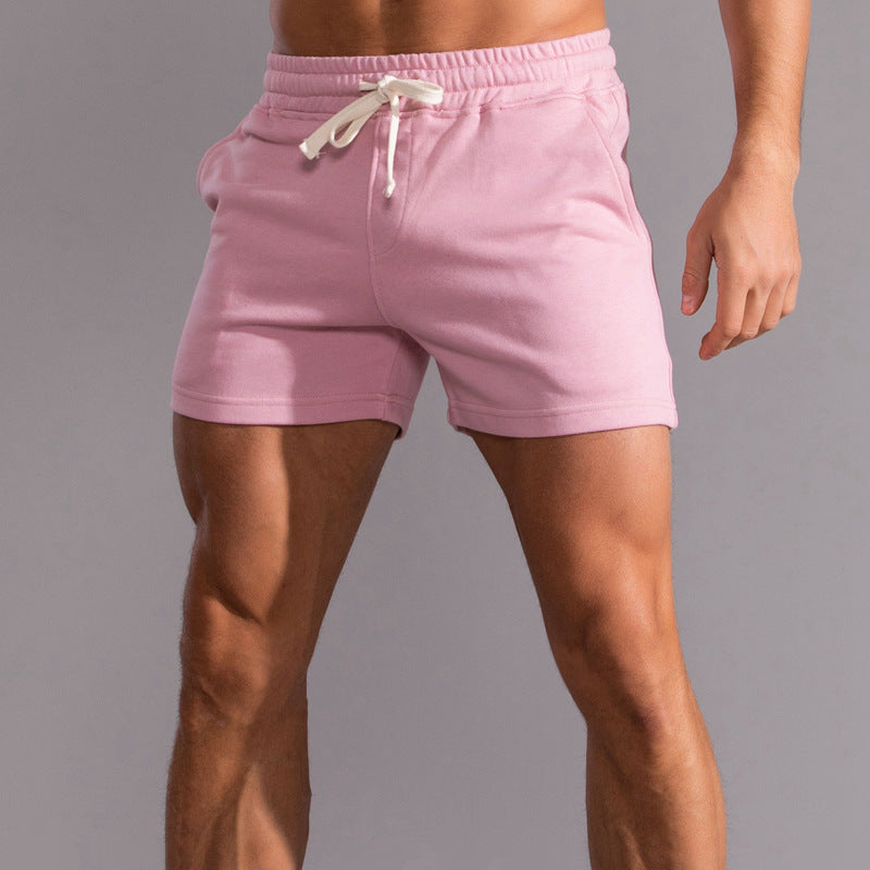 Pink shorts with a white drawstring on a gray background