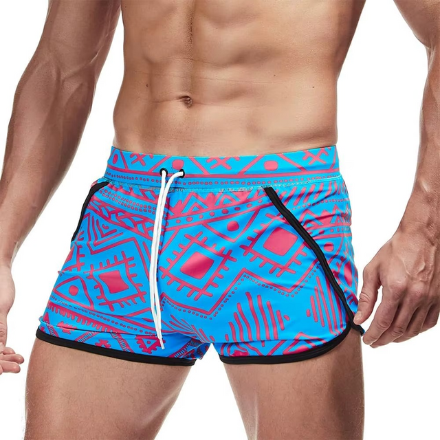 Blue and pink patterned swim shorts worn by a person on a white background