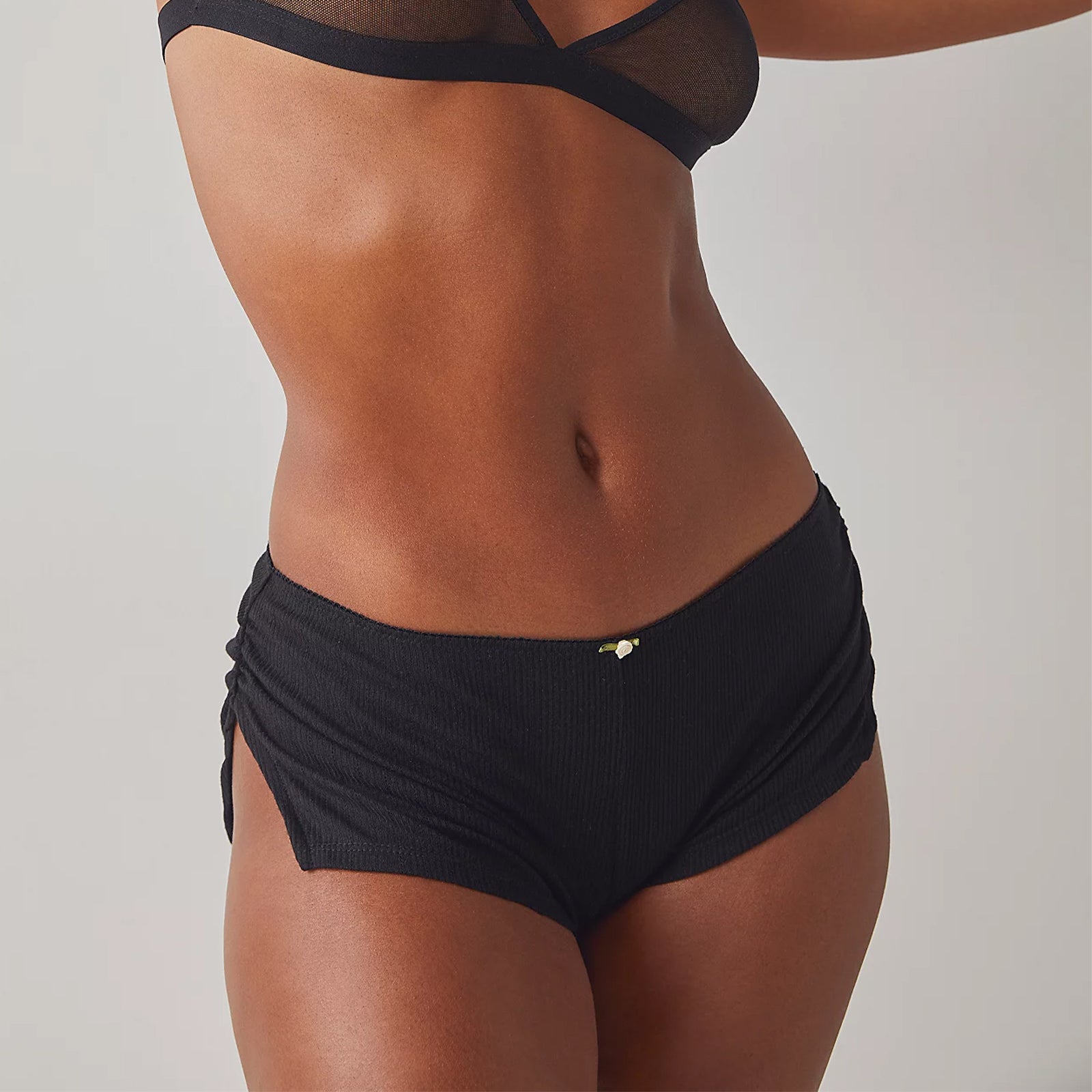 Person wearing a black bikini against a neutral background